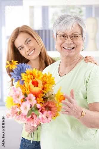 Photo: Happy senior mother with flowers at mother's day Happy senior mother with flowers at mother's day