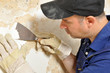 Handwerker beim Entfernen von Tapetenresten