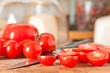Cut cherry tomatoes in foreground and cheese under glass dome in