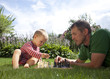 Child and father playing chess in the garden Child and father playing chess in the garden