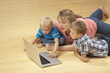 Family watching laptop on the floor Family watching laptop on the floor