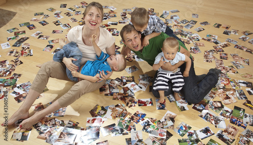Photo: Family having fun on the floor and watching photos Family having fun on the floor and watching photos