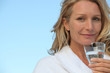Foto: Attractive blonde haired woman drinking a glass of water Attractive blonde haired woman drinking a glass of water