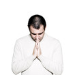 Man with hands clasped praying