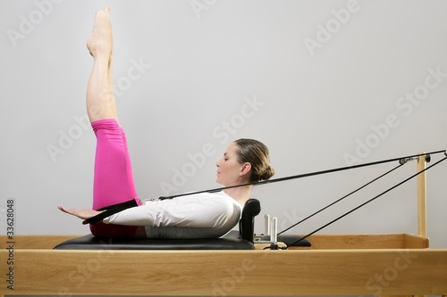 Photo: gym woman pilates stretching sport in reformer bed gym woman pilates stretching sport in reformer bed