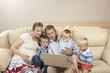 Photo: Family sitting on the sofa and watching laptop Family sitting on the sofa and watching laptop