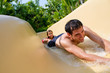 Father and Daughter Sliding Down Water Slide