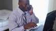 Business man talking on mobile phone and using computer