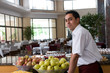 Waiter serving fresh fruits looking at camera.