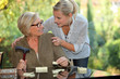 a young blonde woman touching shoulders of an old blonde woman