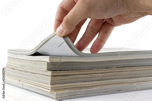 Photo: hand browsing through stack of magazines hand browsing through stack of magazines