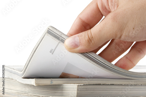 Photo: hand browsing through stack of magazines hand browsing through stack of magazines