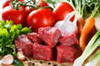 Raw beef on cutting board and vegetables