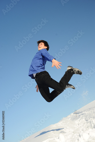 Photo: jumping teenager in blue shirt and black jeans jumping teenager in blue shirt and black jeans