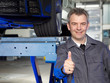 Master mechanic at work shows thumb up
