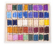 Sewing kit with colored spools of threads isolated on white back
