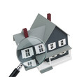 A magnifying glass examining a miniature model home.