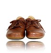 pair of brown leather shoes, face on with reflection