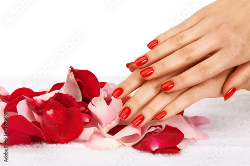 Photo: Closeup image of red manicure with leafs of rose Closeup image of red manicure with leafs of rose