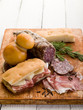 focaccia with ham salami and cheese over cutting board focaccia with ham salami and cheese over cutting board