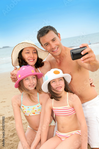 Photo: Family taking picture of themselves at the beach Family taking picture of themselves at the beach
