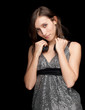 Photo: young woman in silver- black elegant dress, black background young woman in silver- black elegant dress, black background