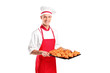 A male baker holding freshly baked croissants A male baker holding freshly baked croissants