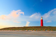 Seaside with sand dunes and lighthouse at sunset Seaside with sand dunes and lighthouse at sunset
