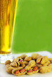 glass of cold beer with peanuts ongreen background