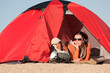 Camping happy woman in tent on beach