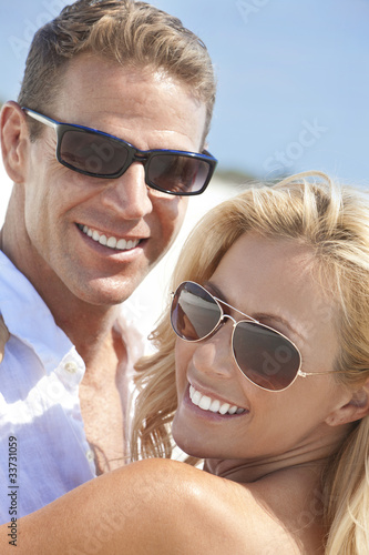 Photo: Happy Attractive Woman and Man Couple In Sunglasses At Beach Happy Attractive Woman and Man Couple In Sunglasses At Beach