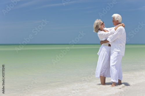 Photo: Happy Senior Couple Embracing on A Tropical Beach Happy Senior Couple Embracing on A Tropical Beach