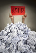 Hands with red frame reaches out from heap of papers