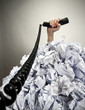 Hand with phone reaches out from heap of papers Hand with phone reaches out from heap of papers