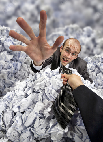 Photo: Helping hand saving buried businessman Helping hand saving buried businessman