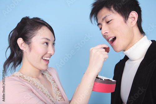 Photo: チョコレートを男性に食べさせる女性 チョコレートを男性に食べさせる女性