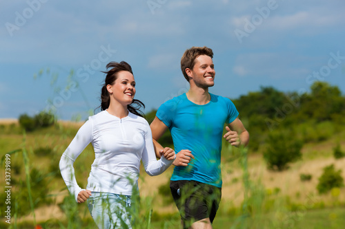 Photo: Young sportive couple is jogging outside Young sportive couple is jogging outside