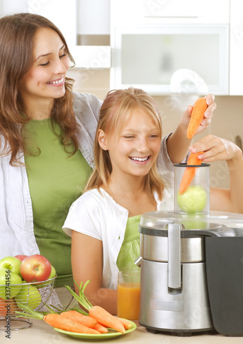 Photo: Happy Family making fresh apple and carrot juice Happy Family making fresh apple and carrot juice