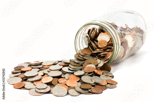 Photo: Jar Of US Coins Spilled On A White Background Jar Of US Coins Spilled On A White Background
