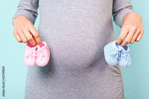 Photo: Pregnant woman holding baby booties Pregnant woman holding baby booties