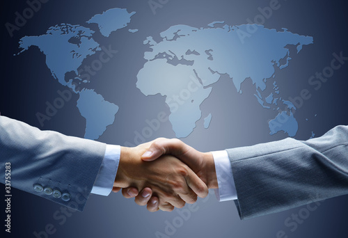 Foto: Handshake with map of the world in background Handshake with map of the world in background