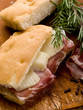 focaccia with speck and cheese over cutting board focaccia with speck and cheese over cutting board