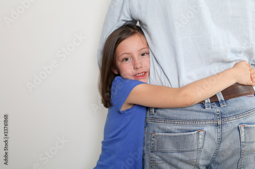 Foto: Little girl putting arms around her father's waist Little girl putting arms around her father's waist