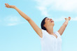 Foto: Joyful young female spreading her arms under the sky Joyful young female spreading her arms under the sky