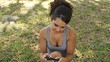 Young female student sending text message outdoors