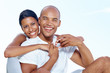 Happy young couple smiling together against sky