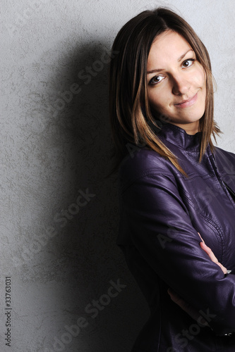 Foto: Young beautiful woman on wall background Young beautiful woman on wall background