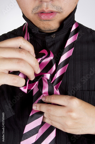 Photo: tie up, male model setting necktie arrange ready to go work. tie up, male model setting necktie arrange ready to go work.