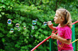 Little girl making  soap bubbles
