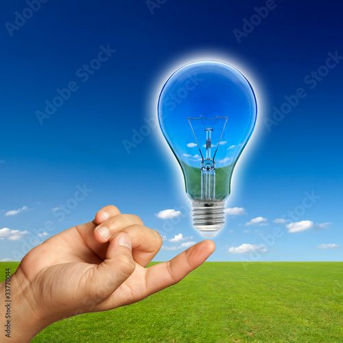 Photo: Ecological concept, reflection of nature in lamp with hand. Ecological concept, reflection of nature in lamp with hand.